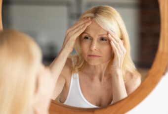 woman wondering why her face is starting to sag