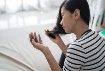 woman wondering why her hair is falling out more than usual